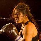 Woman wearing boxing gloves competing in Muay Thai. Image links to Muay Thai club page on Bristol SU Website.
